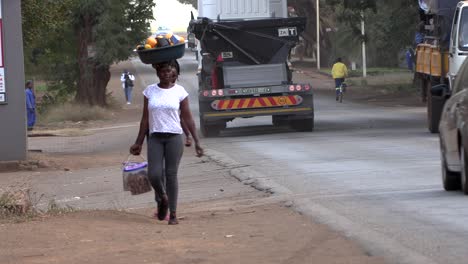 Mujer-Africana-Regresando-Del-Mercado,-Con-Una-Cesta-De-Compras-En-La-Cabeza.