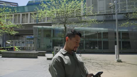 Un-Hombre-Mirando-Su-Teléfono-En-Un-Espacio-Público