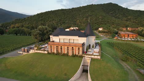 Drone-view-of-Chateau-Buera-Winery-and-Vineyards,-nestled-in-the-lush-green-mountains-near-Lopota-Lake-in-Georgia's-Kakheti-region