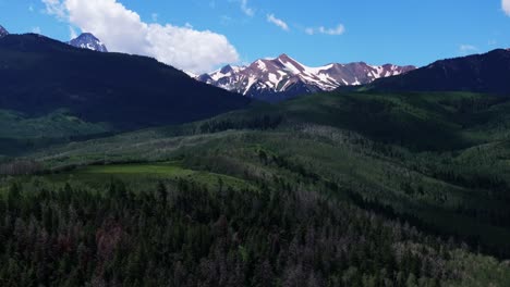 Old-mount-Snowmass-Aspen-Mt-Sopris-Wilderness-aerial-drone-view-early-summer-June-July-Rocky-Mountains-peaks-farm-open-space-landscape-sunny-blue-sky-Capital-Peak-National-Forest-forward-pan-up-motion