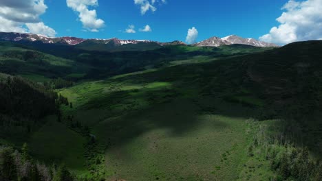 Old-mount-Snowmass-Aspen-Wilderness-aerial-drone-view-early-summer-June-July-Mt-Sopris-Rocky-Mountains-peaks-farm-open-space-landscape-sunny-blue-sky-Capital-Peak-Maroon-Bells-National-Forest-backward