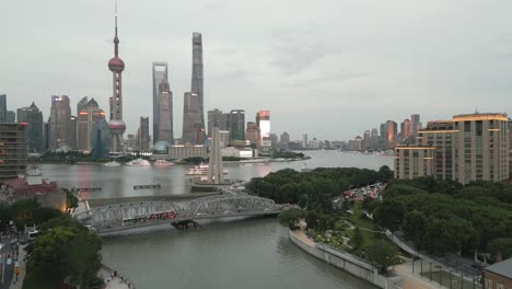 Aerial-View-of-Shanghai-China-Riverfront-Downtown,-street-traffic-and-urban-park-West-Bund-Orbit