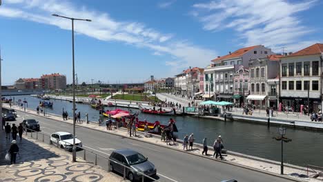 Scenic-view-of-the-beautiful-canal-and-tourists-walking-around-in-downtown-Aveiro,-Portugal