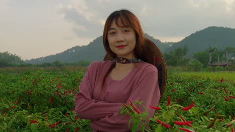 Primer-Plano-Retrato-De-Una-Joven-Vietnamita-Sonriendo-Frente-A-La-Cámara-Con-Un-Sombrero-De-Arroz-Tradicional-De-Pie-En-El-Valle-De-Las-Plantaciones-Agrícolas