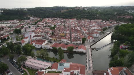 Aerial-view-of-Tomar,-Portugal,-showcasing-its-historic-architecture,-river,-and-surrounding-hills