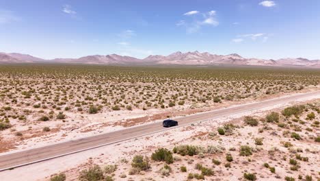 Dron-Siguiendo-A-Un-Auto-Desde-Un-Lado-Conduciendo-Por-El-Desierto-En-4k