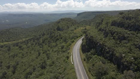 Aerial-of-empty-curved-road-surrounded-by-Mexico-deep-dense-forest,-central-Latin-America