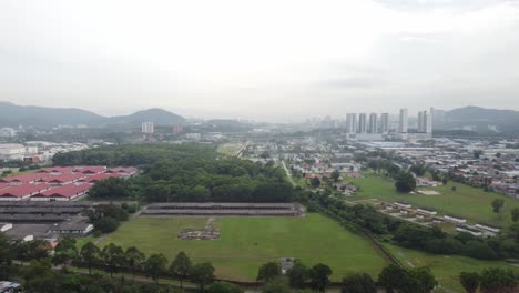 Slow-parallax-shot-around-greenery-and-low-rise-buildings-on-a-misty-midday