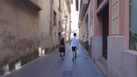 Calle-Estrecha-De-La-Ciudad-De-Palma-De-Mallorca,-Pareja-De-Turistas-Caminando,-España