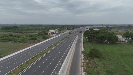 Drone-shot-of-a-busy-market-area-adjacent-to-the-highway,-capturing-the-hustle-and-bustle-of-daily-commerce-and-vibrant-local-life