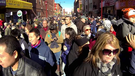 Chinese-American-boy-wearing-tiger-hat-sits-atop-parent's-shoulders-during-new-year-celebration