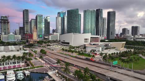 Aerial-establishing-shot-of-marina-with-yachts,-Kaseya-Center-Arena-and-skyline-of-Miami-City-at-sunset