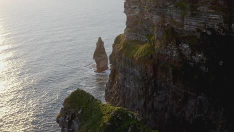 Ruhiger-Sonnenuntergang-An-Den-Klippen-Von-Moher-Mit-Vögeln,-Die-Entlang-Der-Klippen-Und-Des-Brandungspfeilers-Fliegen