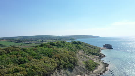 Toma-Aérea-En-Movimiento-Hacia-Adelante-Mirando-Por-Encima-De-Los-Acantilados-Costeros-De-La-Isla-De-Wight,-Con-El-Cielo-Azul-Y-El-Mar-Azul.