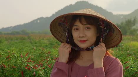 Retrato-De-Mujer-Asiática-Con-Sombrero-De-Arroz-De-Granja-Tradicional-Trabajando-En-Plantaciones-De-Campo