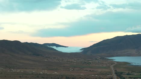 Vista-Sobre-Campos-Marrones-Y-Colinas-Nubladas-En-El-Horizonte-Mientras-Se-Pone-El-Sol-En-Argentina,-Espacio-Para-Copiar,-Toma-Estática