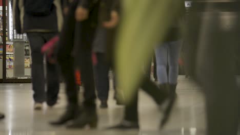 Blurred-scene-of-busy-commuters-at-Schlossgarten-station,-reflections-and-lights-add-to-the-hustle