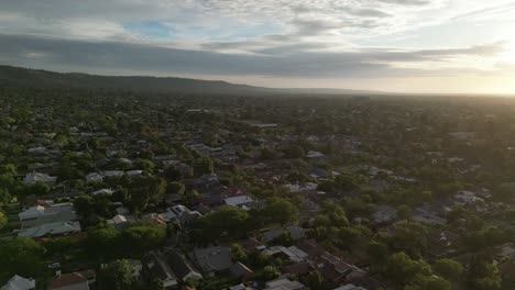 Drone-Shot-Of-Green-City-At-Sunset,-Burnside-Area,-Adelaide-City-Suburbs-In-South-Australia,-CBD-At-Horizon