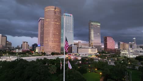 Patriotische-Amerikanische-Flagge-Auf-Halbmast-Vor-Der-Skyline-In-Tampa-City-Bei-Nacht