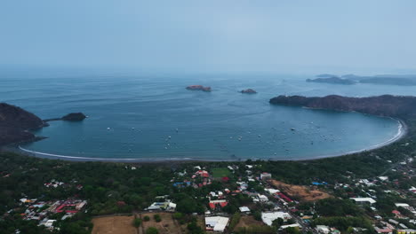 Aerial-view-backwards-over-the-coast-of-Flamingo-Guanacaste,-sunny-Costa-Rica