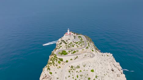 Aerial-approach-toward-Formentor-Lighthouse-on-limestone-cliff-edge,-Spain