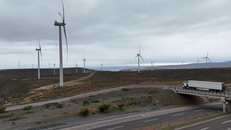 Camión-En-Pasarela-Y-Detrás-De-Un-Parque-Eólico-En-Funcionamiento-En-La-Región-De-Coquimbo,-País-De-Chile