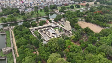 Aerial-Drone-Shot-of-Temple-Surrounded-by-Trees,-Ponds-and-Buildings