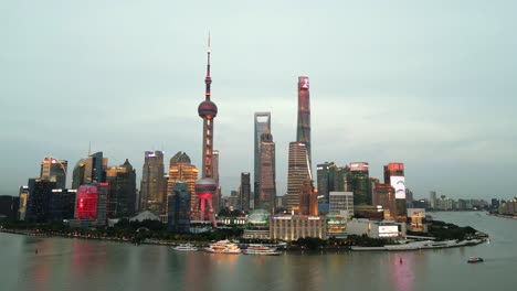 Aerial-Drone-Fly-Huangpu-River-flow-through-downtown-Shanghai,-fireworks-skyline