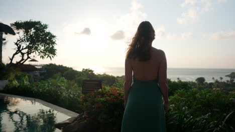 Young-female-tourist-stands-poised-against-rising-Asian-sun-backdrop