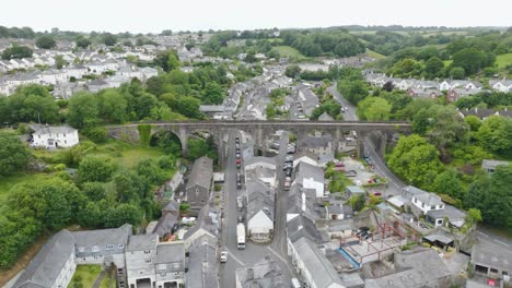 Aerial-view-of-Tavistock-Viaduct-surrounded-by-lush-greenery-and-residential-houses,-Tavistock,-Devon,-UK