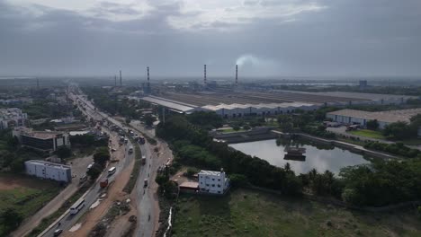 Aerial-view-of-a-serene-sunset-over-the-highway-with-traffic-near-factory