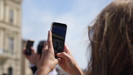 Slow-motion-shot-of-a-woman-recording-the-Triumphal-Arch-at-the-Olympic-event