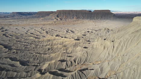 Vista-Aérea-Del-Paisaje-Gris-Seco-Y-árido-Y-Formaciones-De-Butte,-Paisaje-Desértico-Parecido-A-La-Luna-De-Utah,-EE.UU.