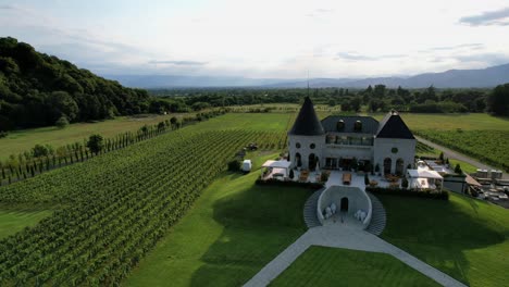 Drone-view-of-Chateau-Buera-Winery-and-Vineyards,-nestled-in-the-lush-green-mountains-near-Lopota-Lake-in-Georgia's-Kakheti-region