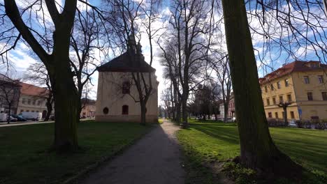 Walking-on-a-pathway-towards-the-church-and-the-square-in-bohemian-town-Kostelec-nad-Černými-Lesy