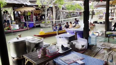 established-of-floating-market-with-wooden-boat-carrying-tourist-tasting-traditional-thai-food-in-market-stalls