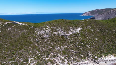 4K-drone-video-flying-over-two-people-hiking-the-Bald-Head-Walking-Trail-within-the-Torndirrup-National-Park-in-Albany,-Western-Australia