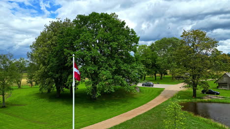 Latvian-flag-on-a-flagpole-over-a-countryside-near-Riga