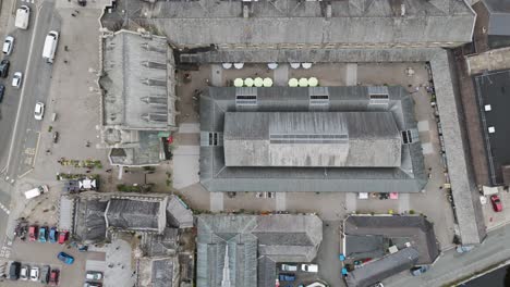 Top-down-drone-view-of-Tavistock-Pannier-Market,-showcasing-the-market-stalls,-buildings,-and-layout,-Devon,-UK