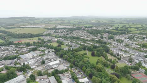 Aerial-flyover-of-the-west-side-of-Tavistock,-showcasing-residential-areas,-green-fields,-and-winding-roads,-Devon,-UK