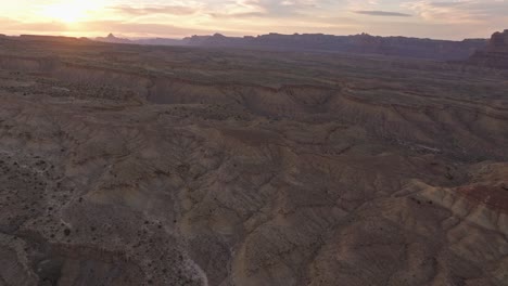 Aerial-view-of-the-sun-setting-over-a-mesa-desert-landscape