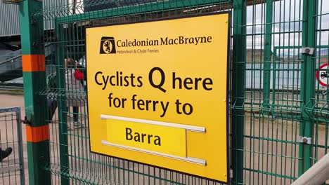 Radfahrer-Stehen-Hier-Schlange,-Schild-Für-Die-Caledonian-Macbrayne-Fähre-Zur-Weiterreise-Zu-Den-Äußeren-Hebriden-Im-Hafen-Von-Oban,-Schottland,-Vereinigtes-Königreich