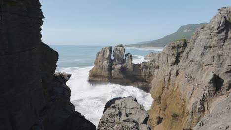 Waves-crashing-against-rocks-on-a-sunny-summer-day-at-Punakaiki-Pancake-Rocks,-West-Coast,-New-Zealand