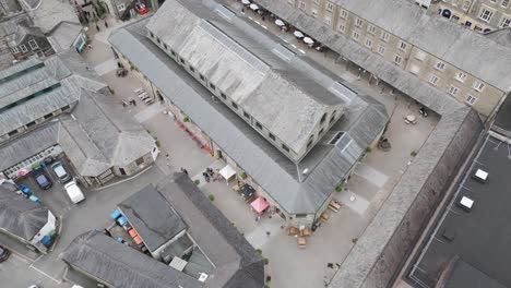 Aerial-view-of-Tavistock-Pannier-Market-showcasing-its-structure-and-surrounding-buildings,-Devon,-UK