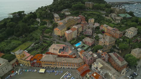 Sestri-Levante,-a-charming-town-in-Liguria,-Italy,-showcases-colorful-buildings,-a-sandy-beach-with-boats-lined-up,-and-lush-greenery