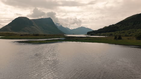 Vista-Aérea-De-Drones-De-Lofoten-Noruega-Volando-Bajo-Hacia-El-Océano-Y-Revelando-Un-Hermoso-Paisaje-En-Verano