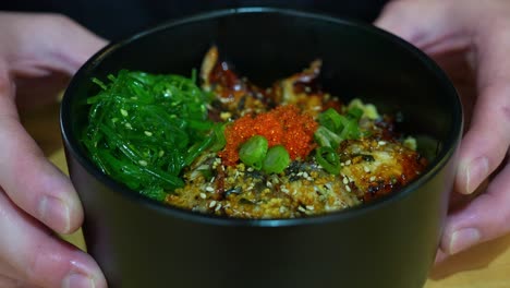 Popular-Japanese-rice-bowl-dish,-Unadon,-grilled-eel-glazed-with-a-thick,-sweet-soy-flavoured-sauce-on-top-of-steamed-rice,-pair-with-seaweed-salad-and-fish-roes,-close-up-shot