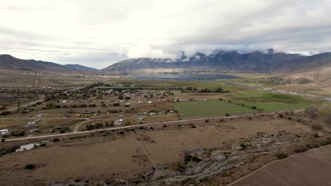 Wide-brown-and-green-fields-of-the-agriculture-in-an-argentinian-province-with-mountains-and-lakes,-forward-in-slow-motion-and-copy-space