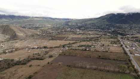 Forward-moving-on-the-fields-nearby-the-city-of-Tafi-del-Valle-with-cloudy-mountains,-slowmotion-in-Argentina