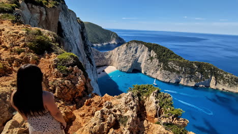 Brunette-greek-woman-admire-Zakynthos-Navagio-beach,-blue-water,-Greece